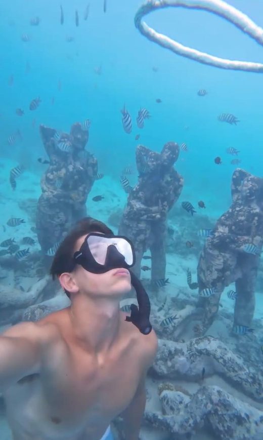 George under the underwater statues off Gili Meno with a bubble ring above