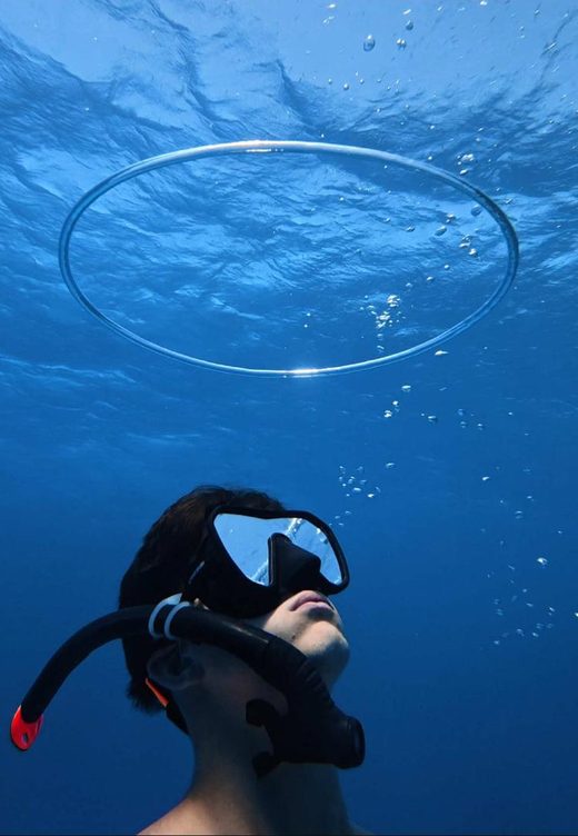 George under a wide bubble ring near the surface